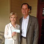 Charlie Caswell delivers check to Sally Hale the Executive Director of Camp Sunshine